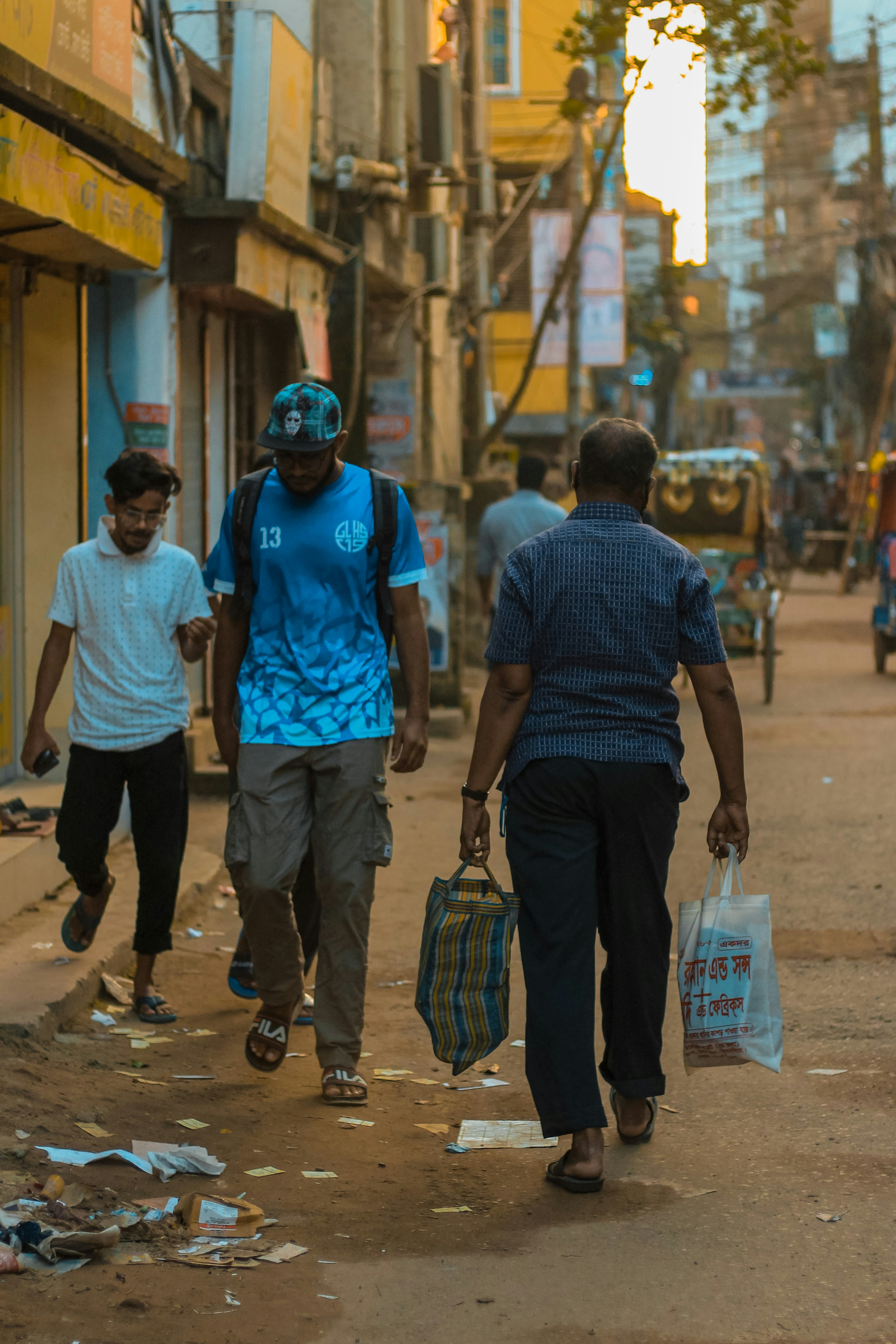 man in blue crew neck t-shirt and black pants holding black and brown leather handbag