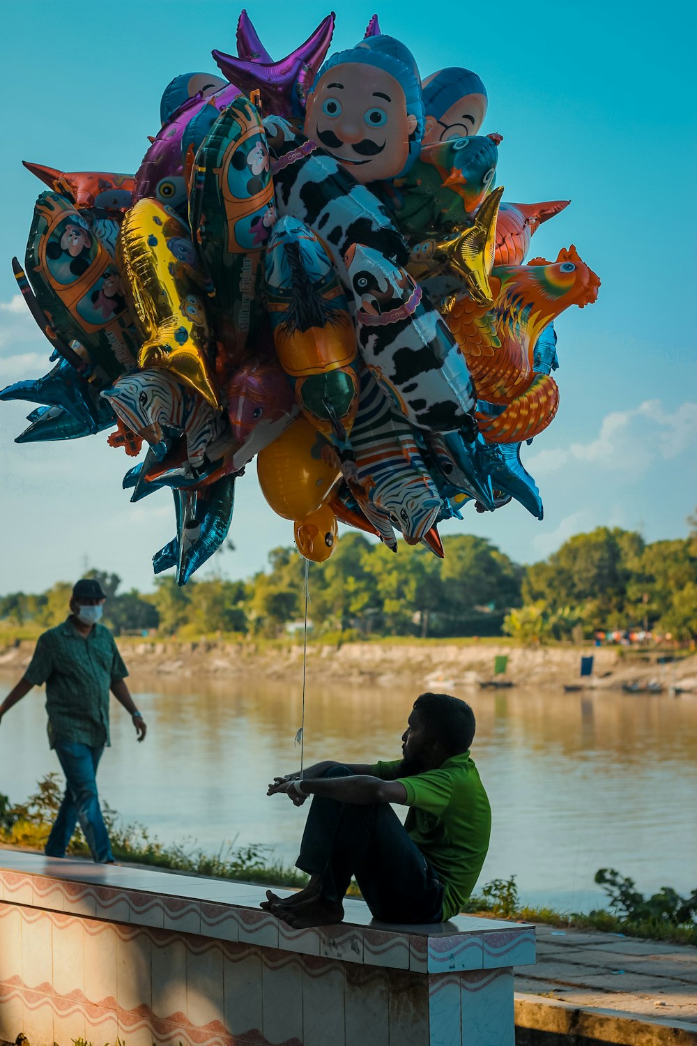people walking on body of water with dragon balloons during daytime