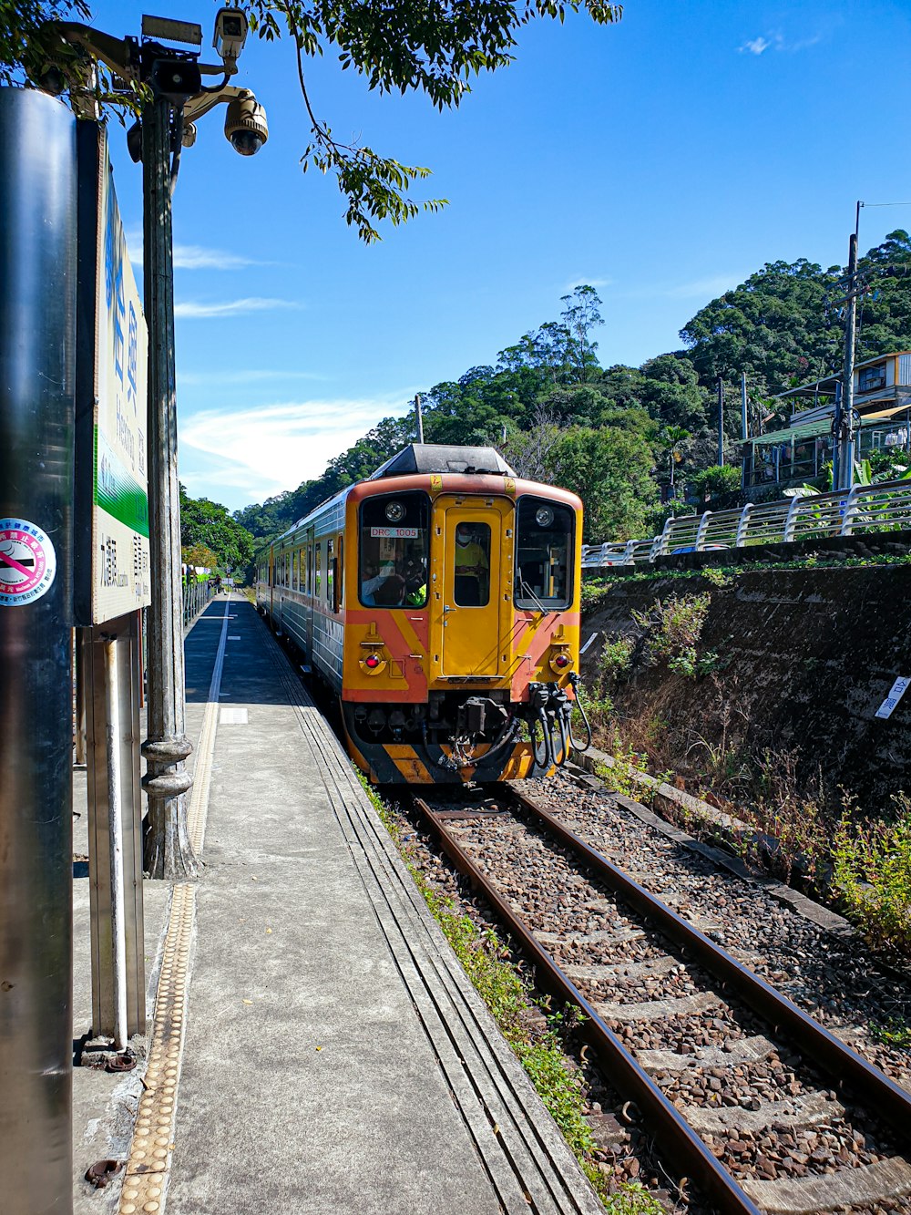 yellow and black train on rail road during daytime