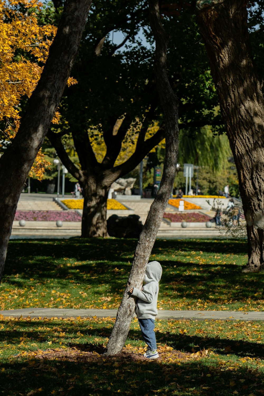 person in white hoodie walking on sidewalk during daytime