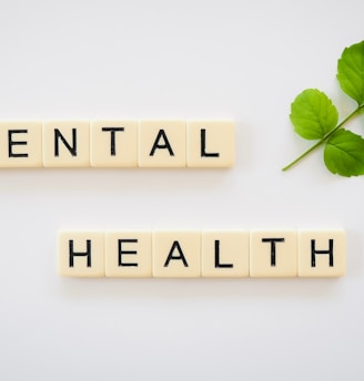 the word mental health spelled with scrabbles next to a green leaf