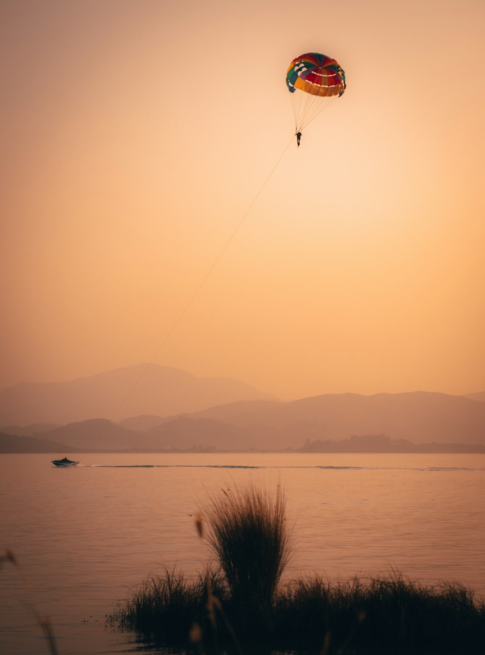 person on parachute over the sea during daytime