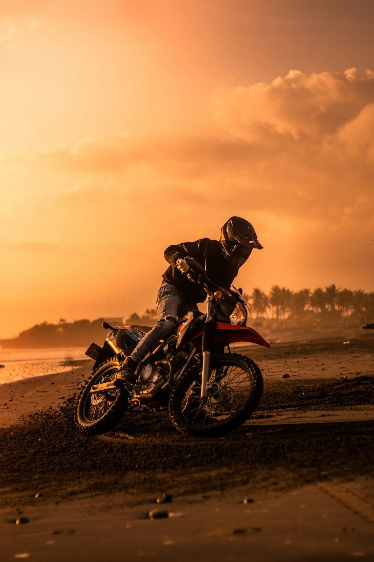silhouette of man riding motorcycle on beach during sunset