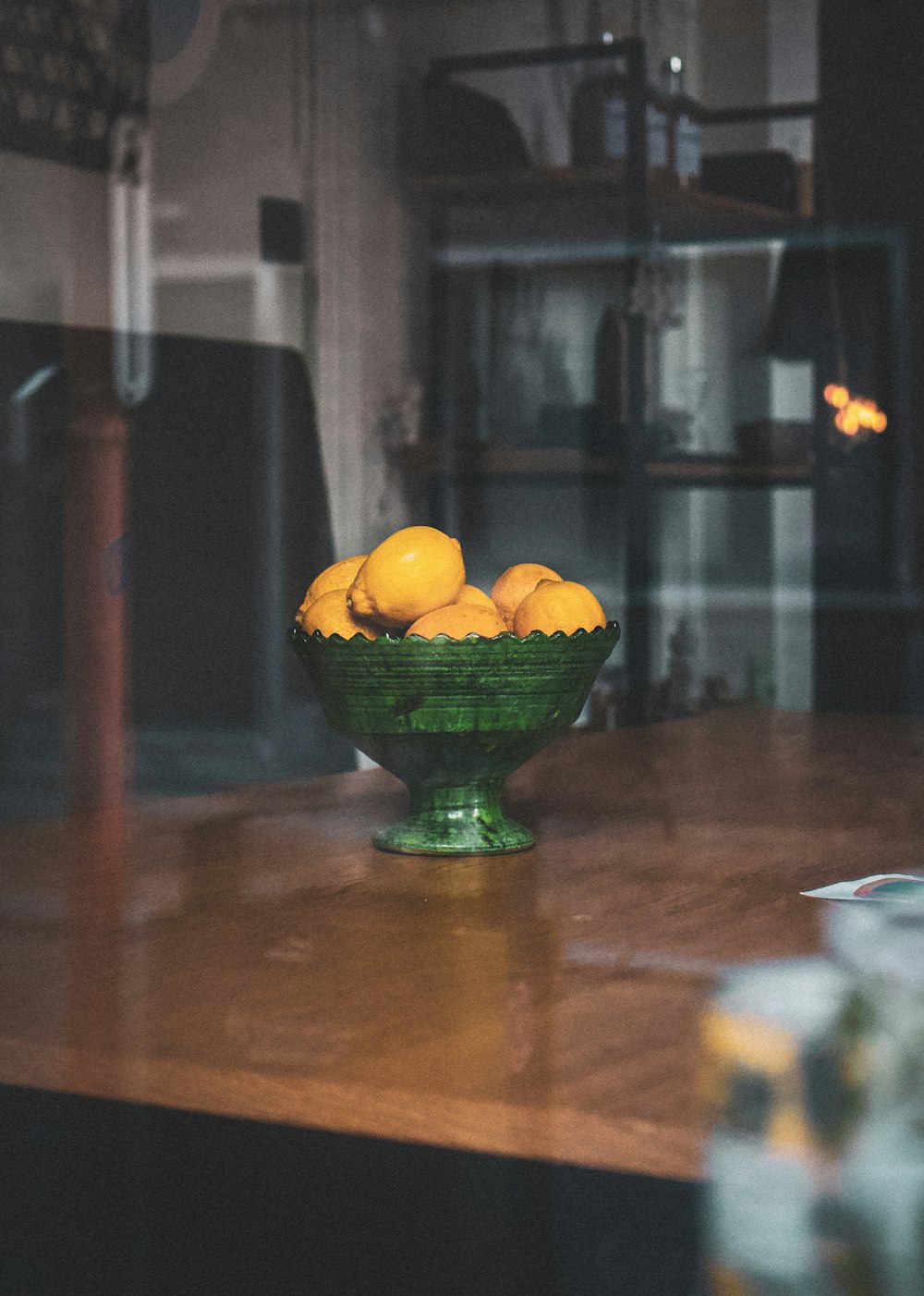 orange fruits in green ceramic bowl