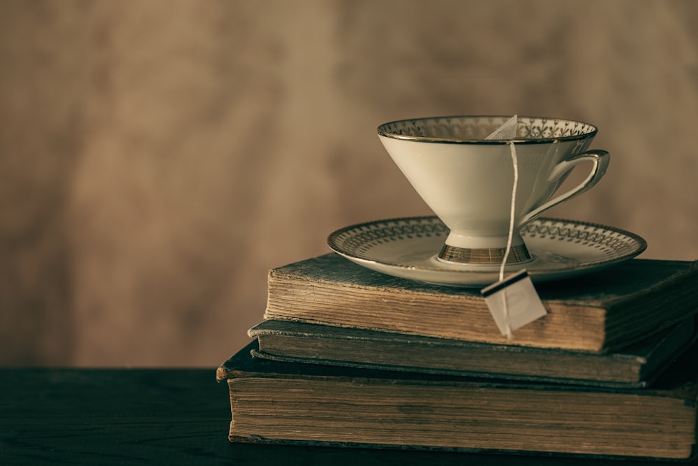 white ceramic teacup on book