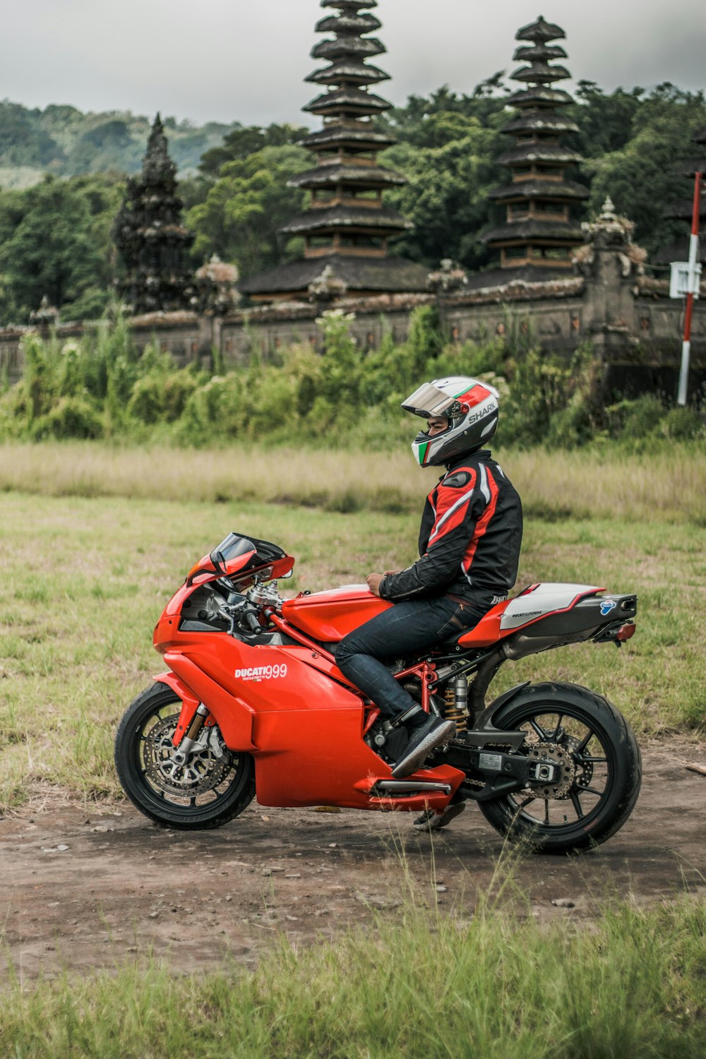 man in black and orange jacket riding orange sports bike