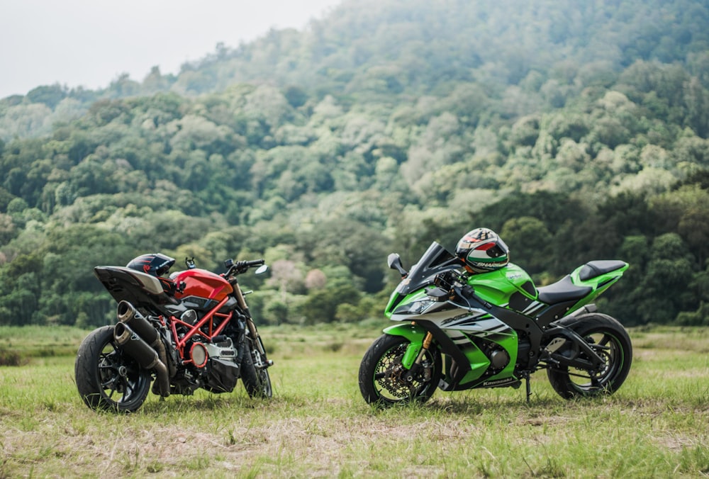 green and black sports bike on green grass field during daytime