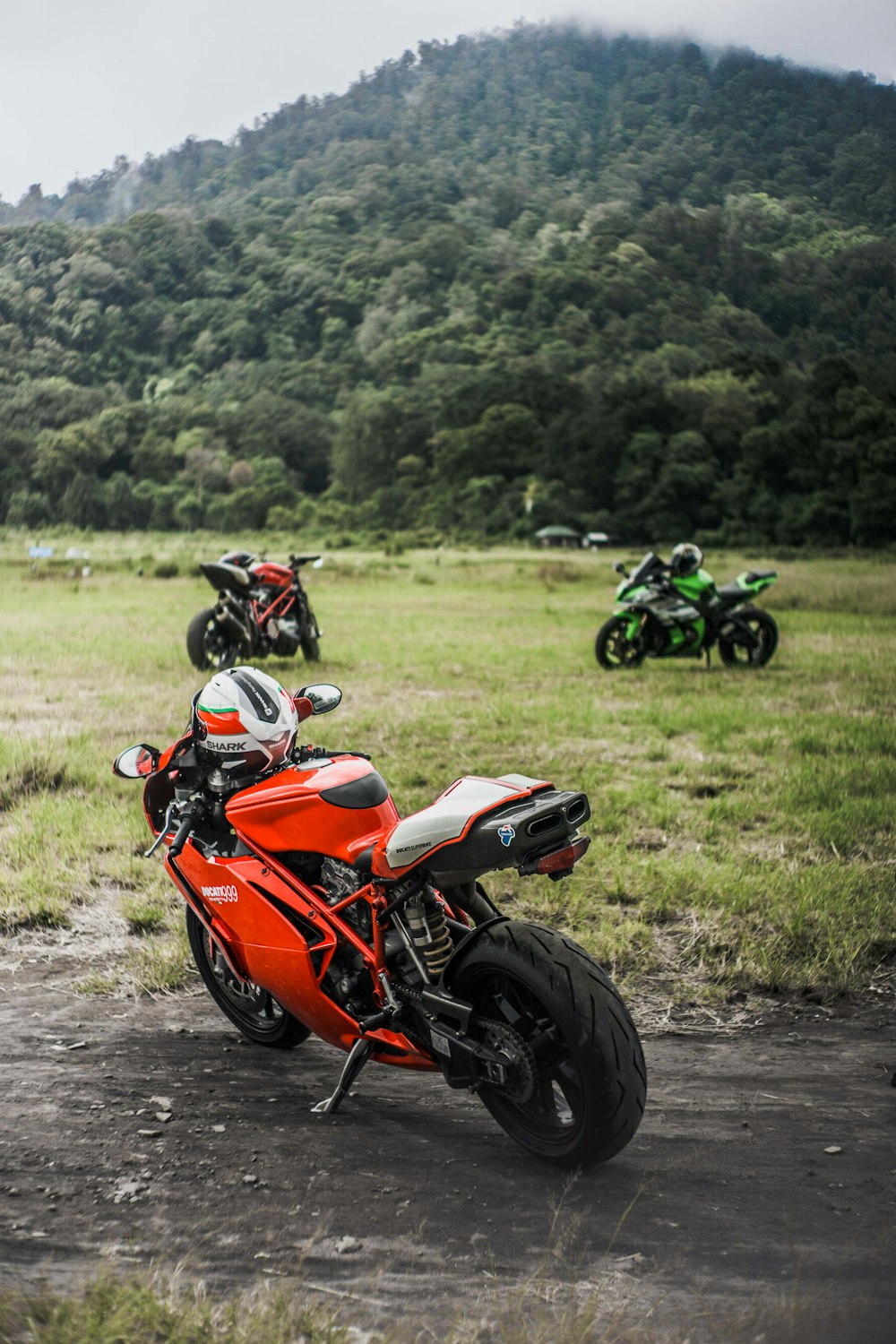 orange and black sports bike on dirt road during daytime