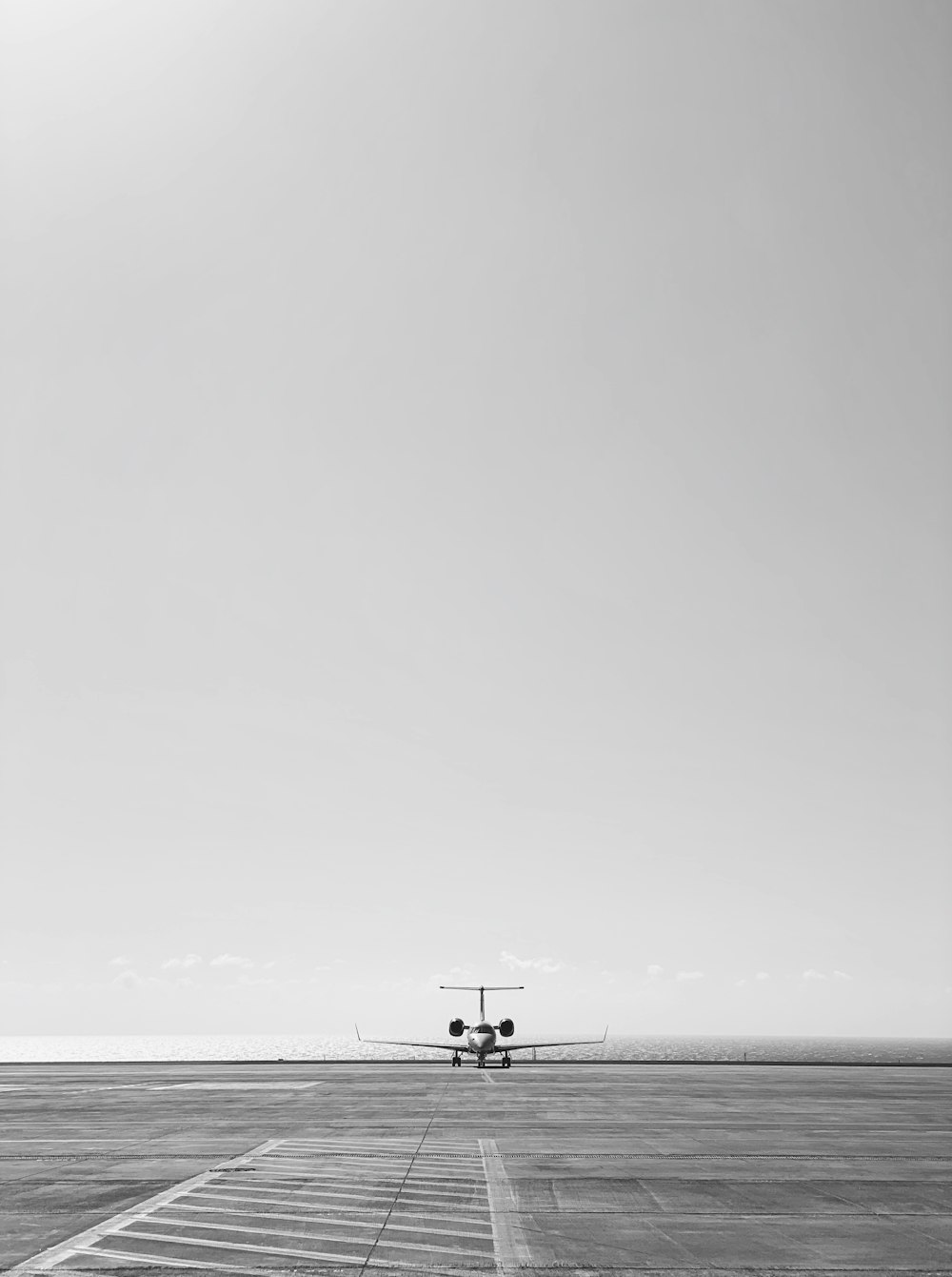 grayscale photo of 2 people walking on beach