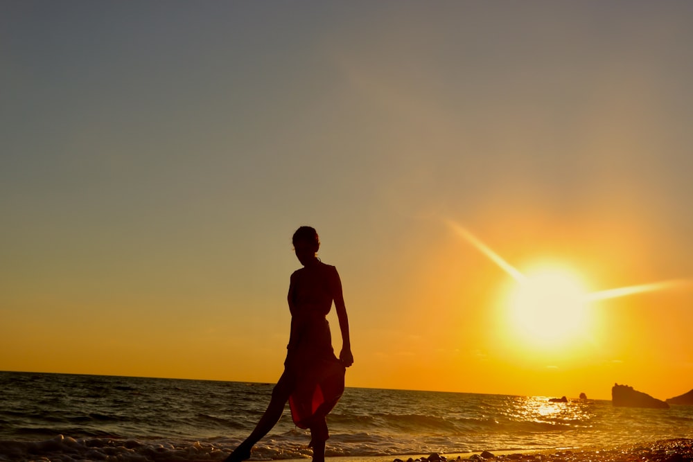 man standing on beach during sunset