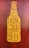 A graphic stylized as a beer bottle with the text 'Good People Drink Good Beer' written in bold, uppercase letters. The design features a mustard yellow bottle shape against a textured, dark reddish-brown background.