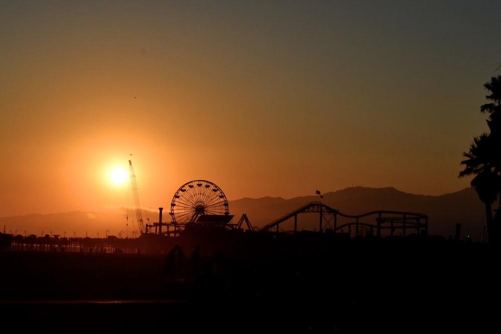 silhueta da roda gigante durante o pôr do sol