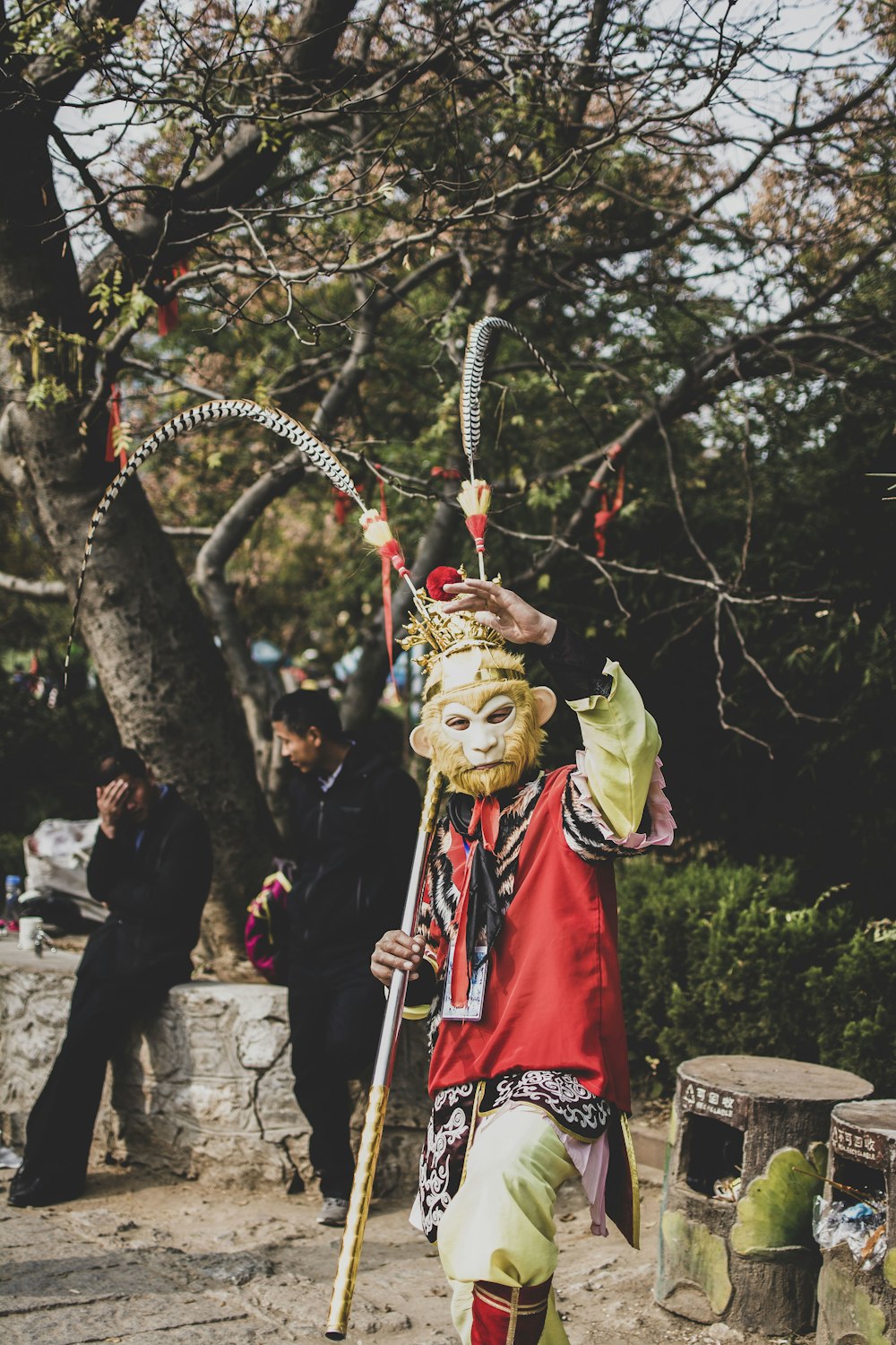 people in green and red costume standing near trees during daytime