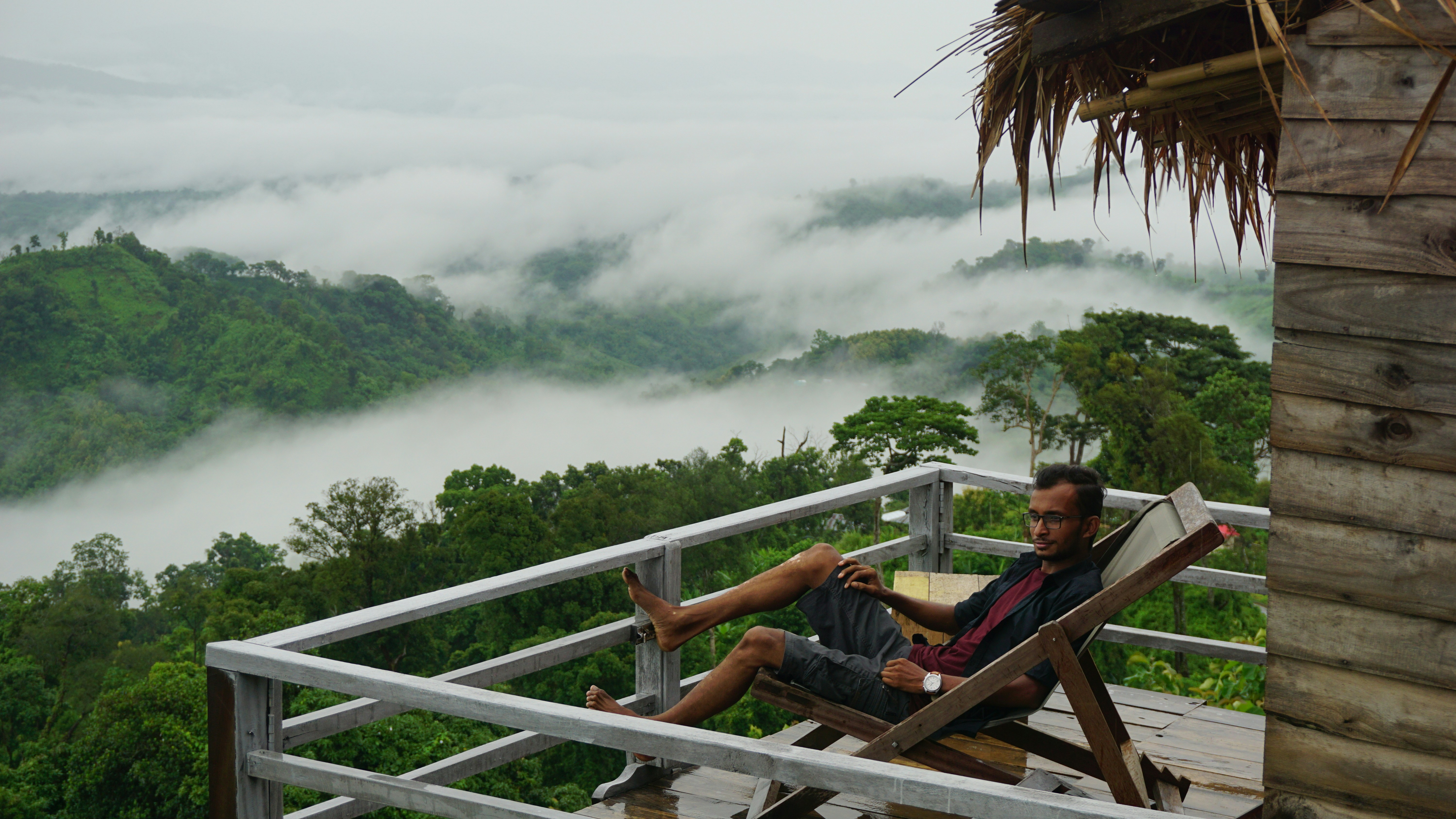 man in blue shirt sitting on brown wooden chair