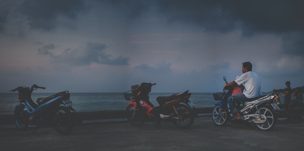 Motocicletta nera e rossa sulla spiaggia durante il giorno