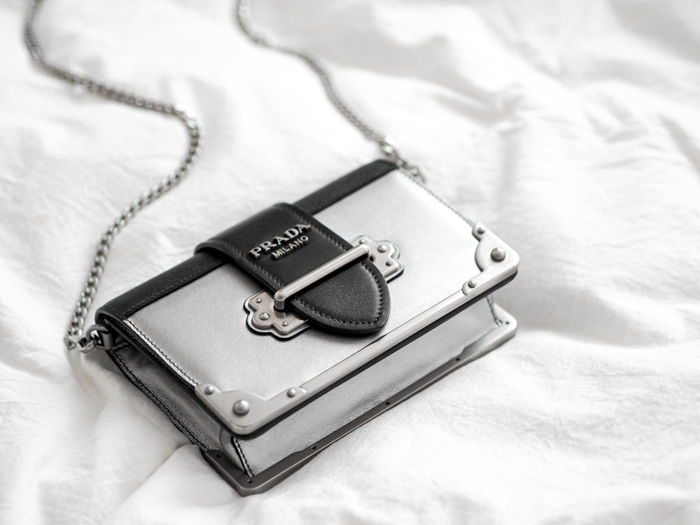 black leather sling bag on white textile