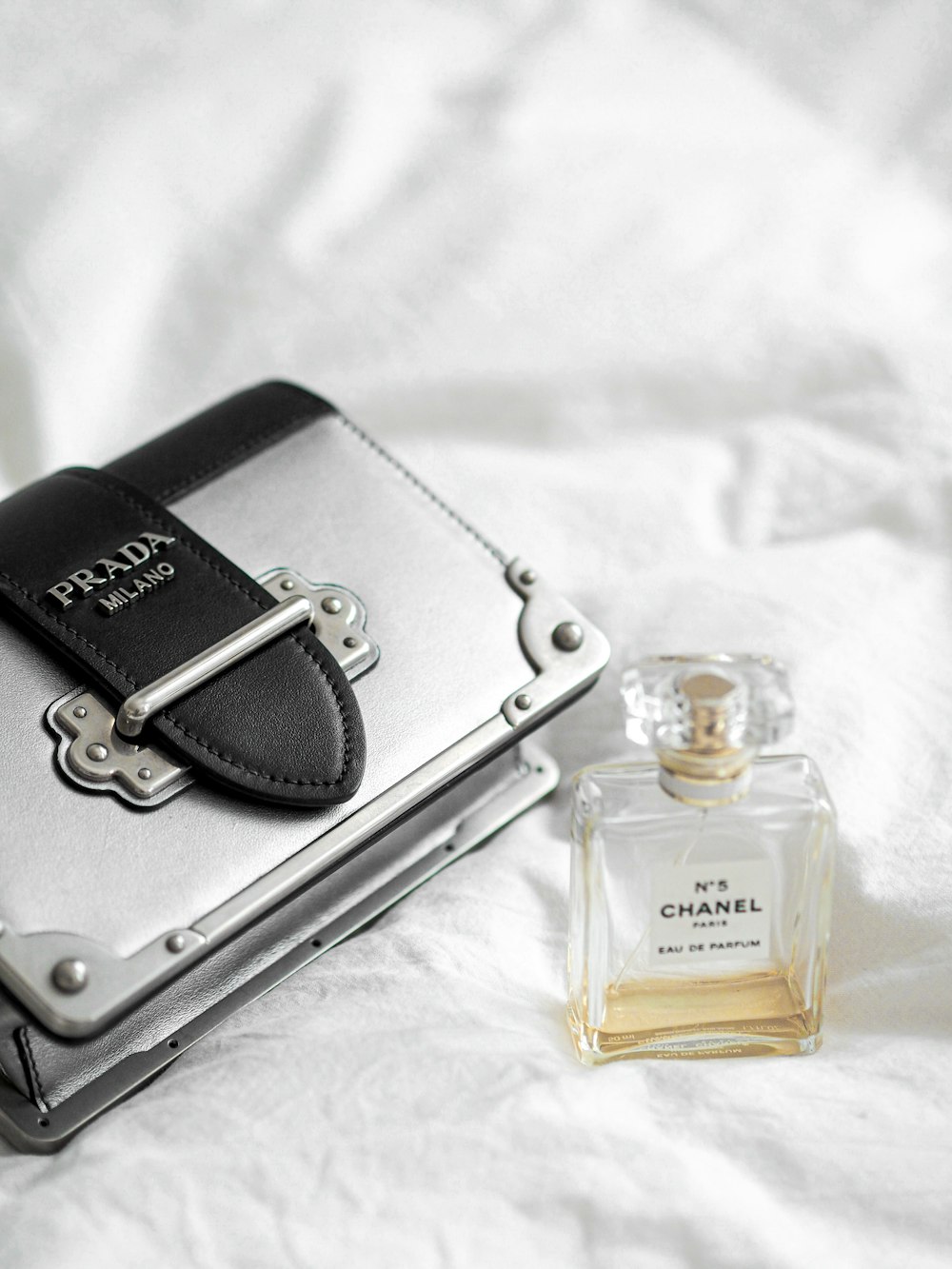 black leather pouch beside clear glass bottle