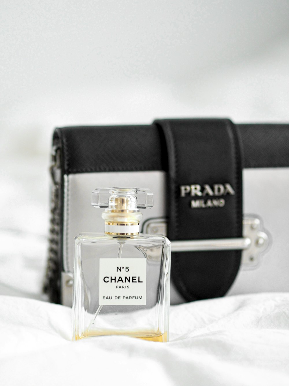 black leather bag with clear glass perfume bottle