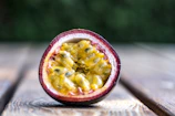 Passion fruits halved to show their golden, juicy seeds against a soft white backdrop.