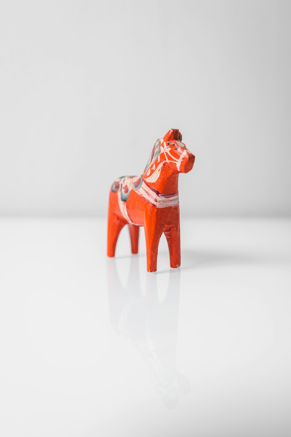 red ceramic figurine on white surface