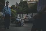 man in blue jacket standing beside road during daytime