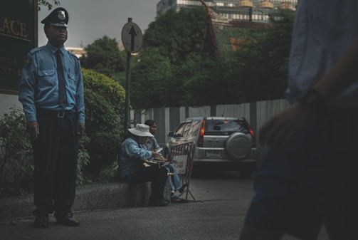 man in blue jacket standing beside road during daytime