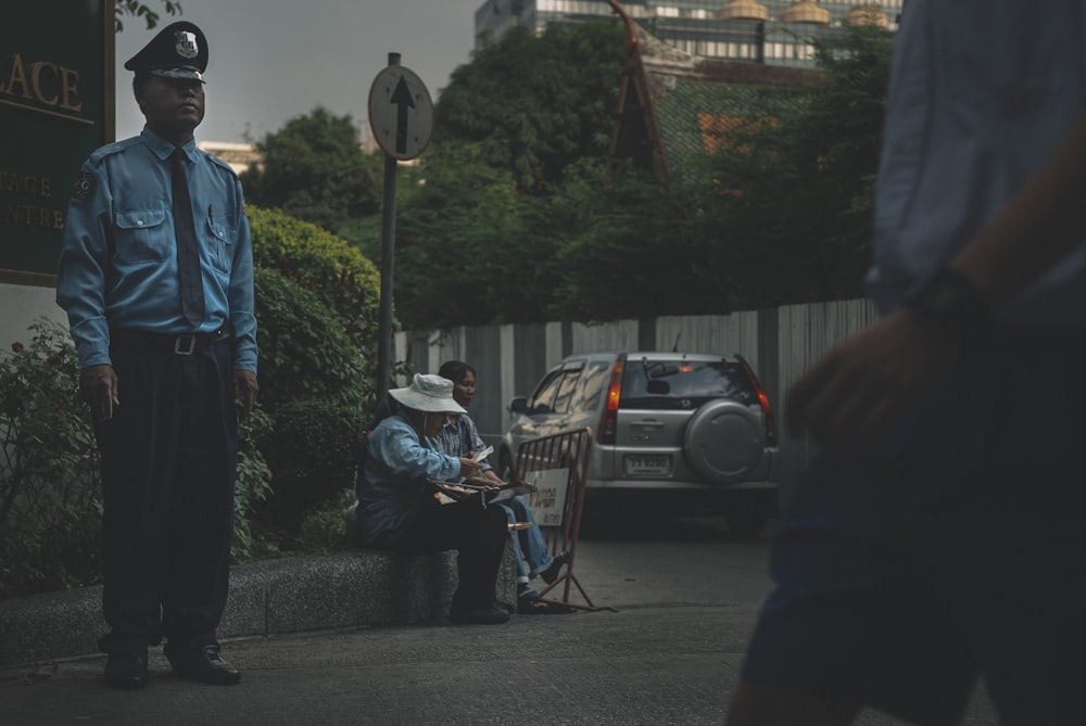 man in blue jacket standing beside road during daytime