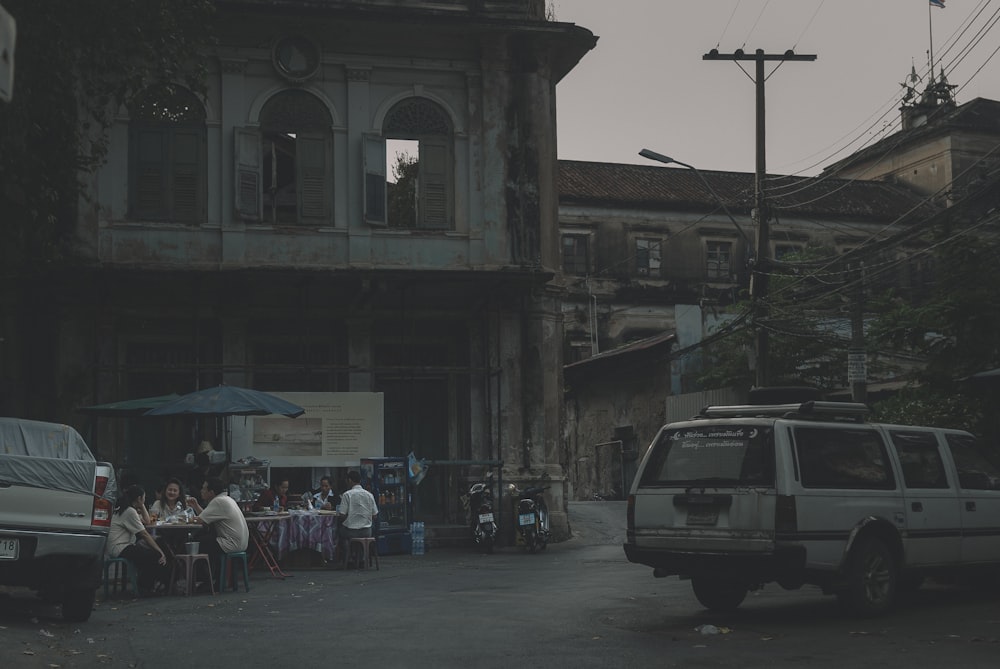 people walking on sidewalk near cars and buildings during daytime