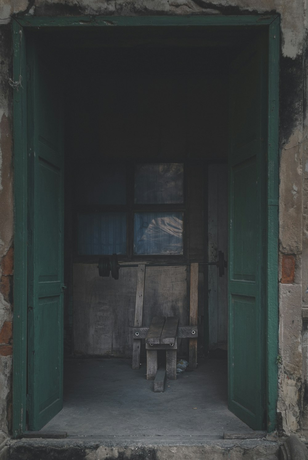 green wooden door with glass panel