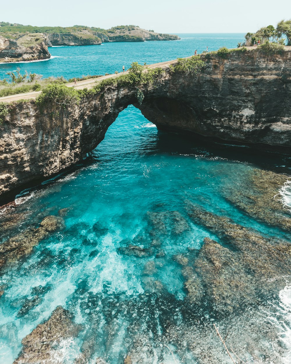 formação rochosa marrom ao lado do mar azul durante o dia