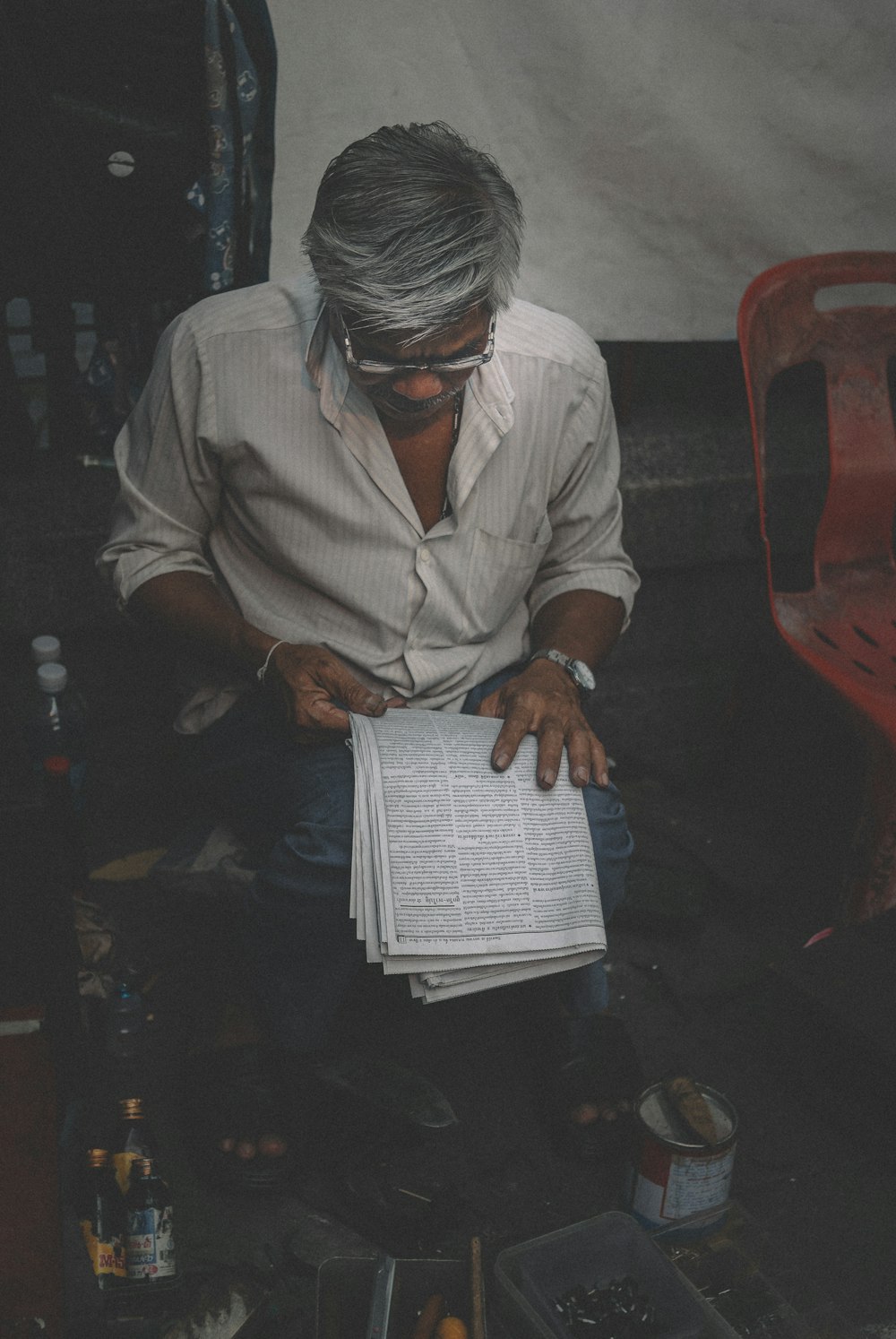 man in white dress shirt reading book