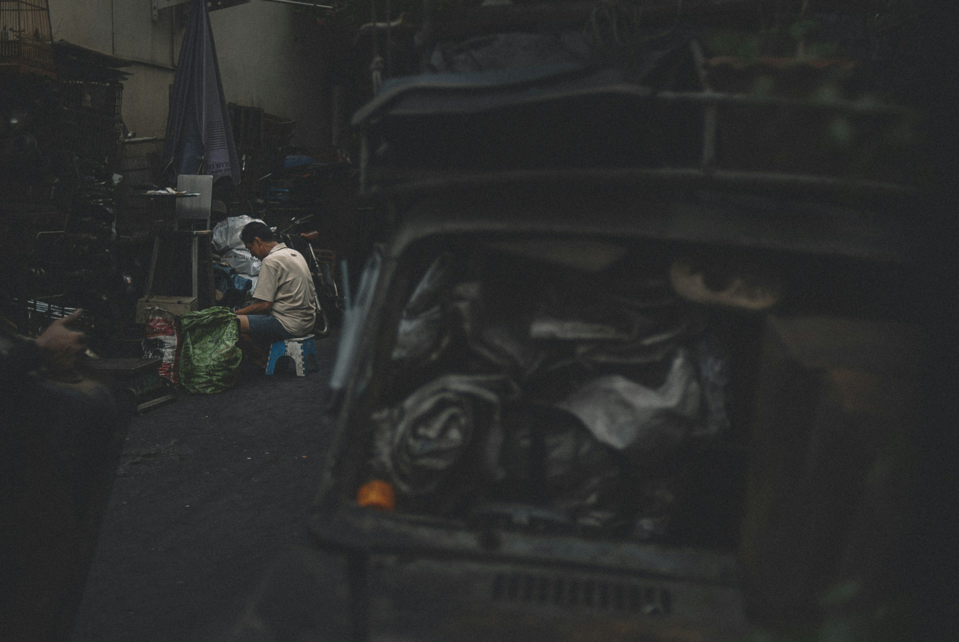 man in white long sleeve shirt and green pants sitting on black car