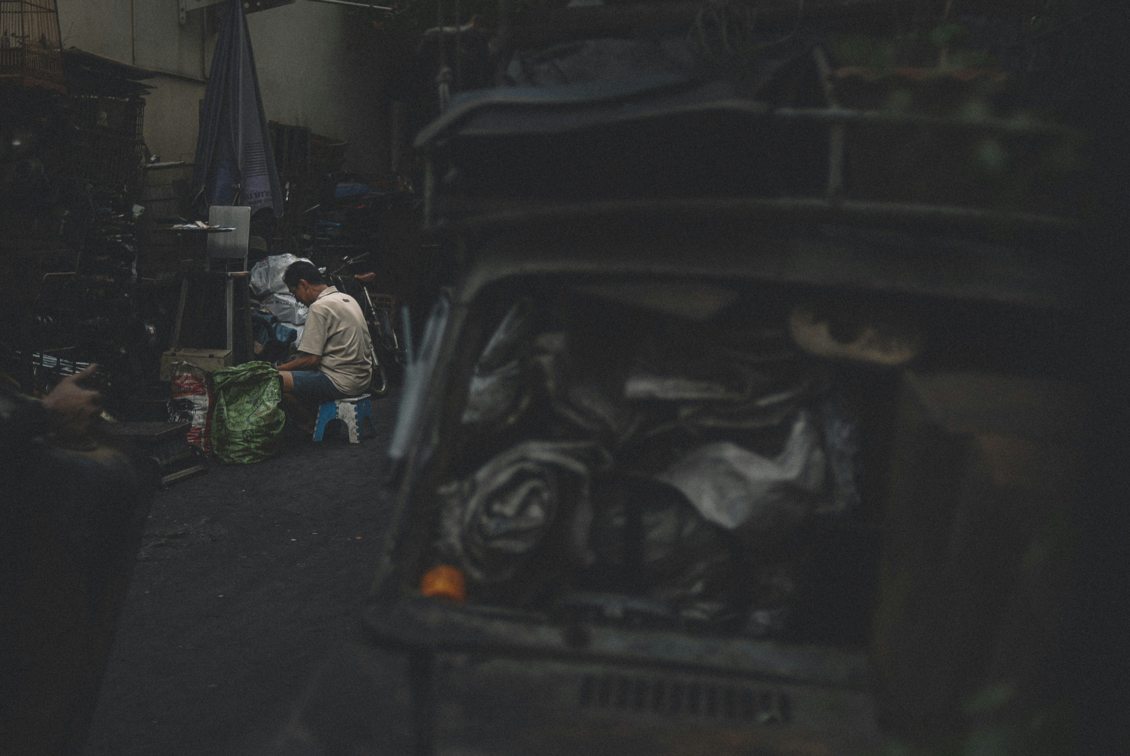 A worker works in a slum full of old cars and spare parts in Bangkok.