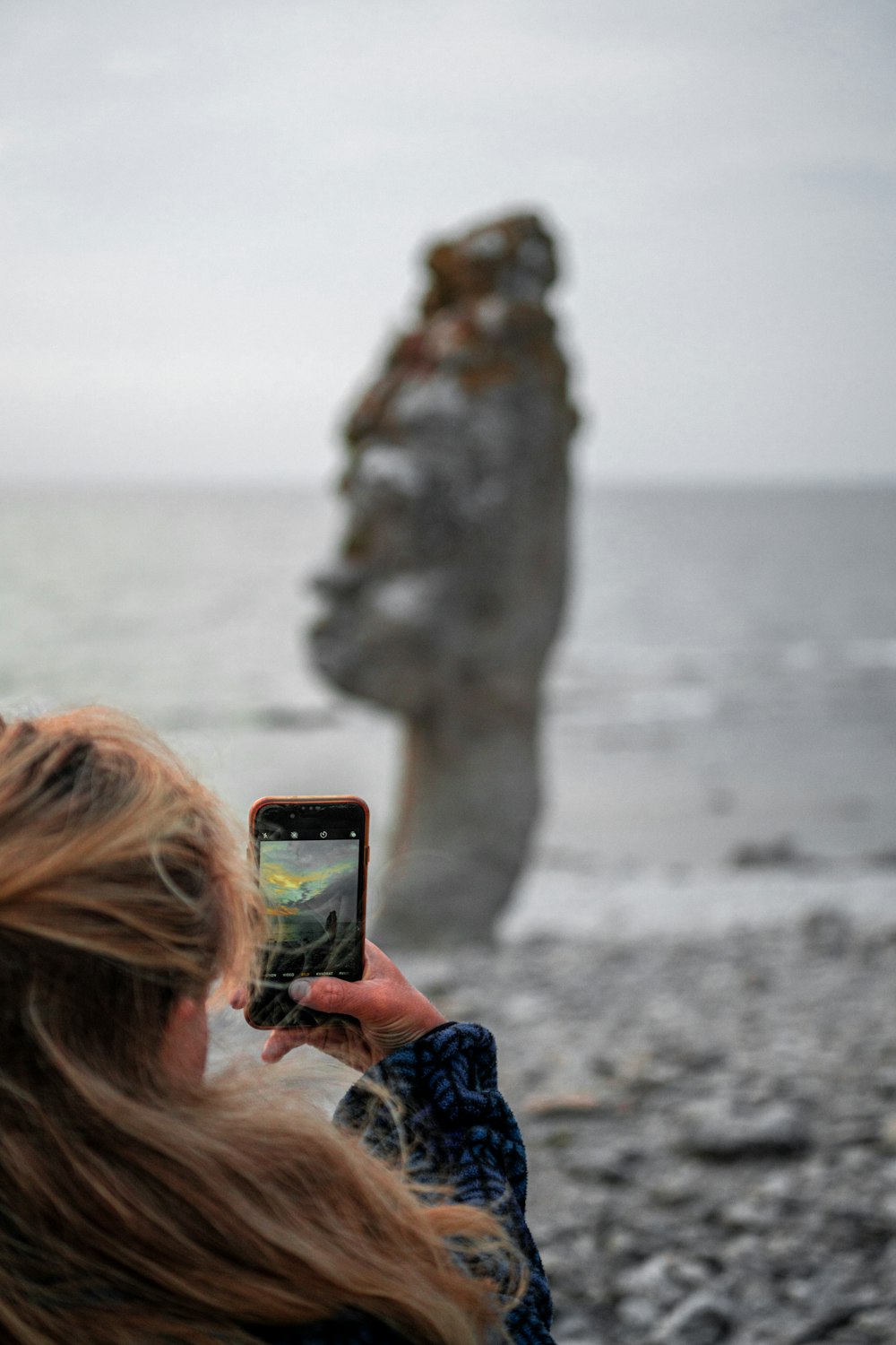 Mujer tomando foto de la formación rocosa durante el día