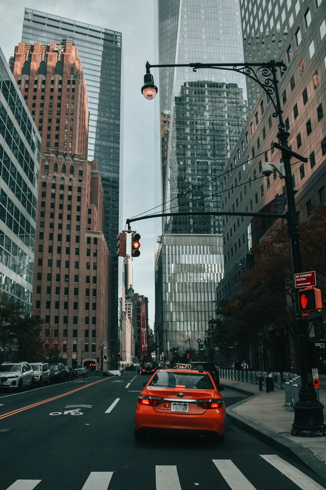 red car on road near high rise buildings during daytime