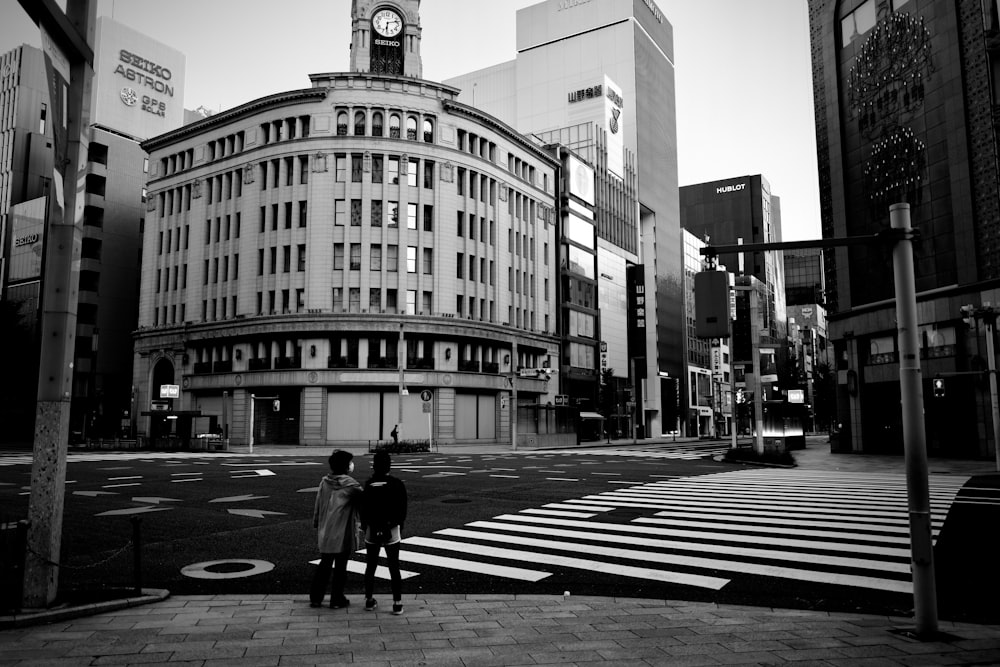 grayscale photo of man walking on pedestrian lane