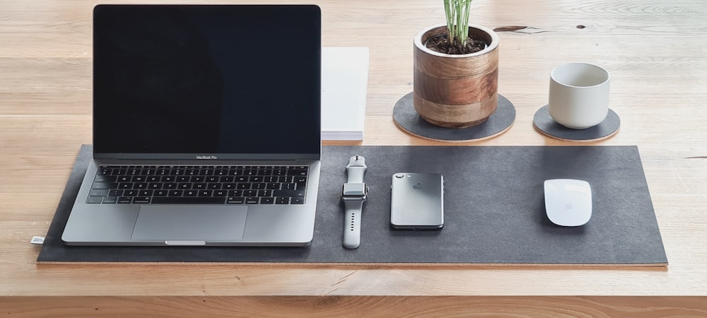 macbook pro beside silver iphone 6 on brown wooden table