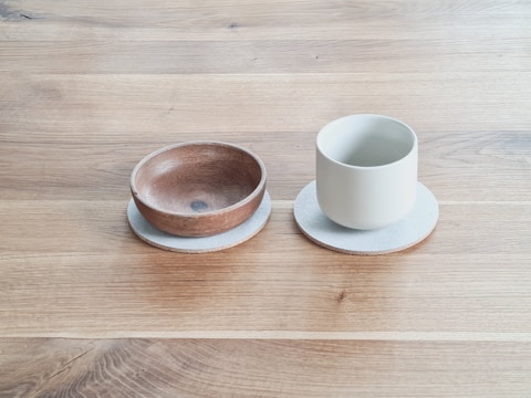 Hand-carved wooden bowls paired with leather coasters.