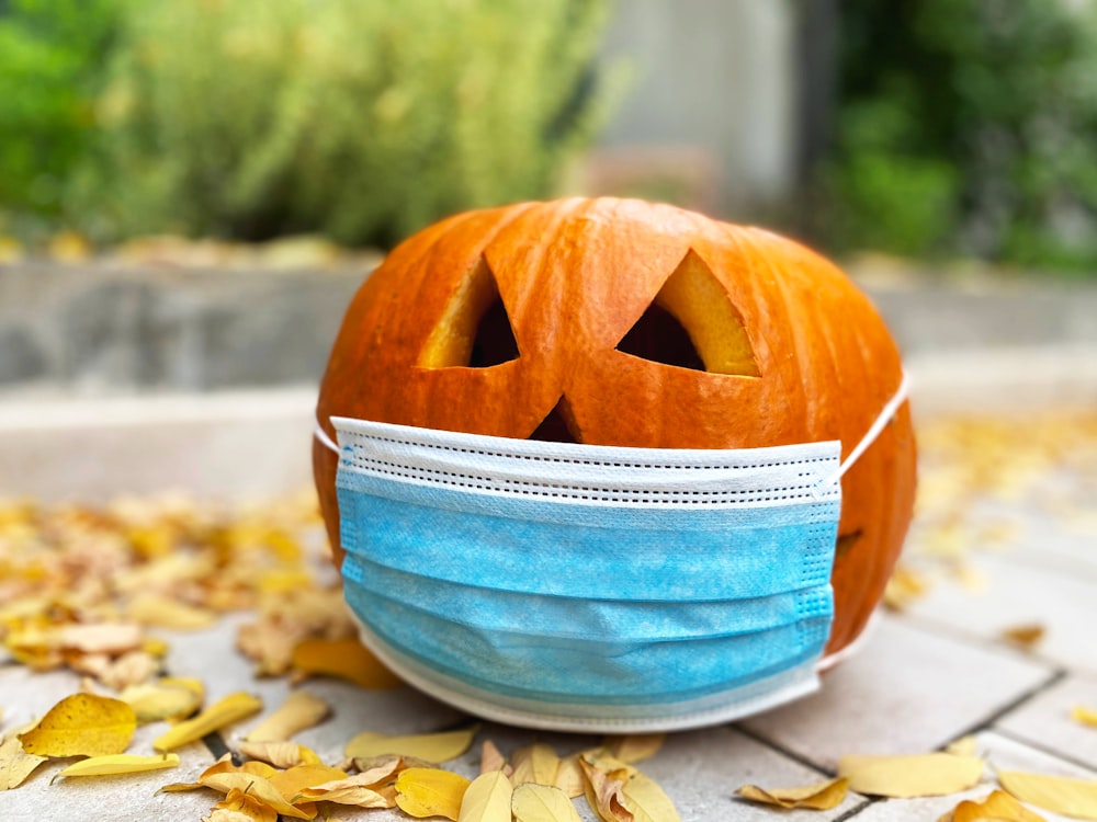 orange jack o lantern on blue and white striped textile