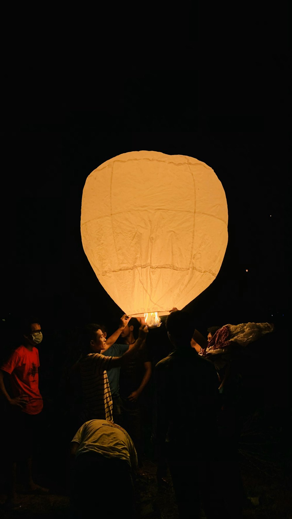 people holding yellow hot air balloon during night time