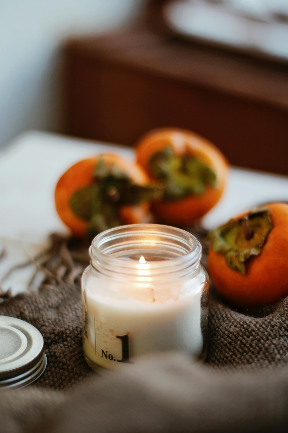 white pillar candle on gray textile