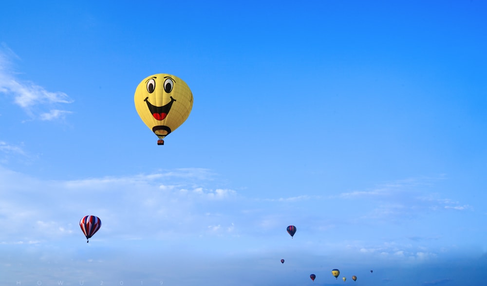 yellow and red hot air balloon in mid air under blue sky during daytime