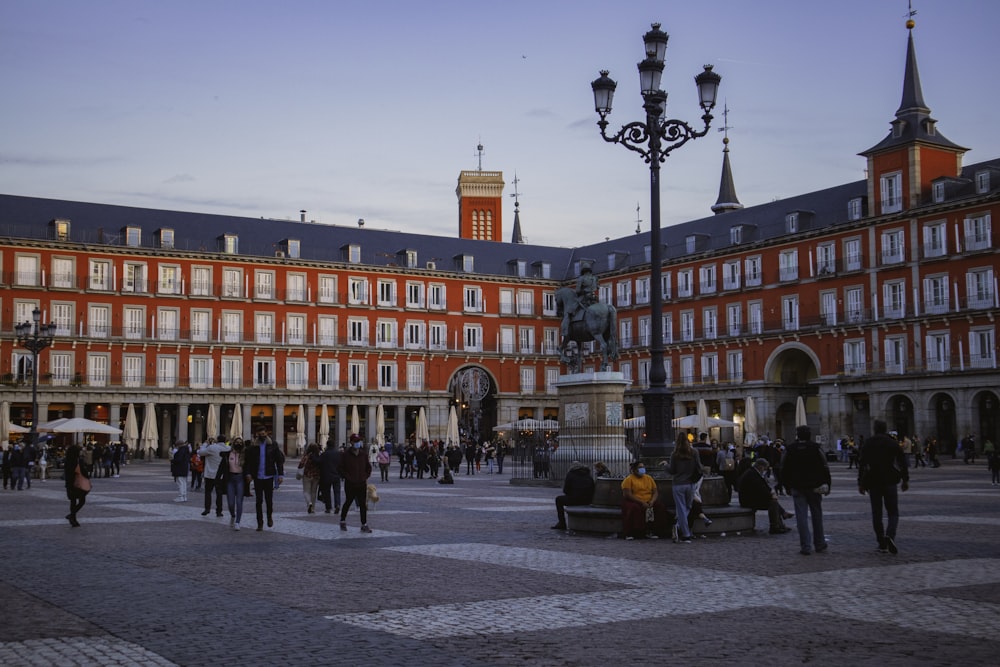 people walking on street near red concrete building during daytime