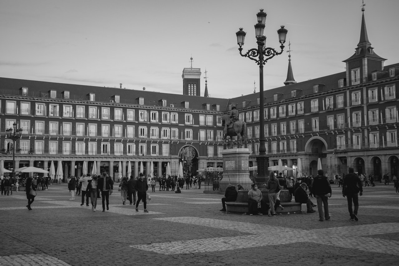 Plaza mayor people walking on street near red concrete building during daytime