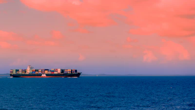 cargo ship on sea under cloudy sky during daytime