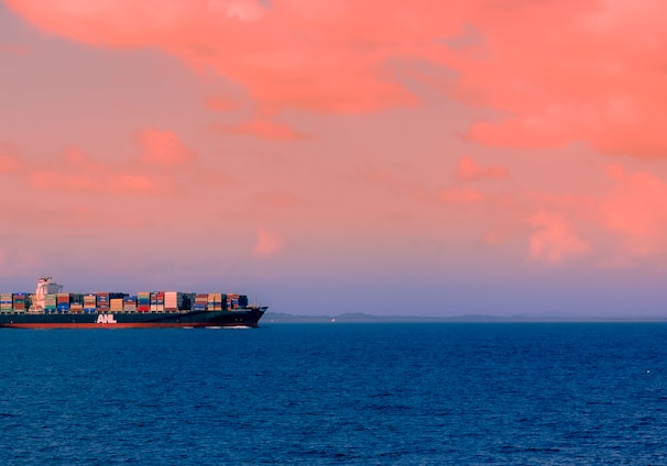 cargo ship on sea under cloudy sky during daytime