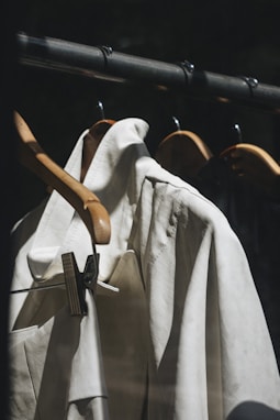 white dress shirt hanged on brown wooden clothes hanger
