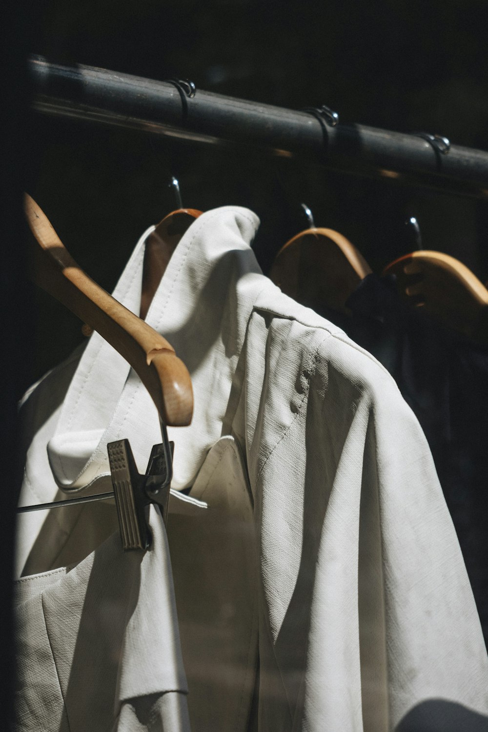 white dress shirt hanged on brown wooden clothes hanger