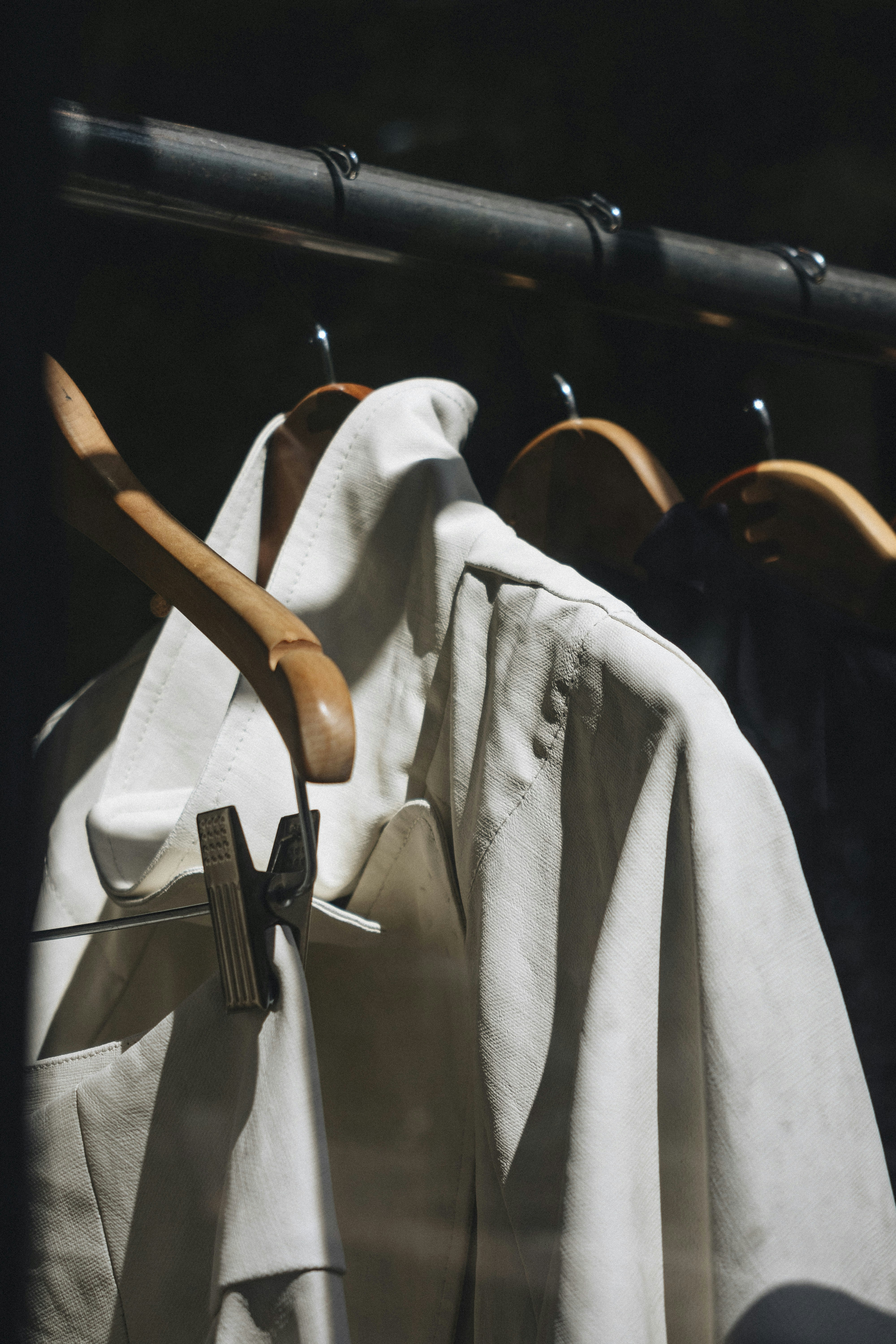 white-dress-shirt-hanged-on-brown-wooden-clothes-hanger