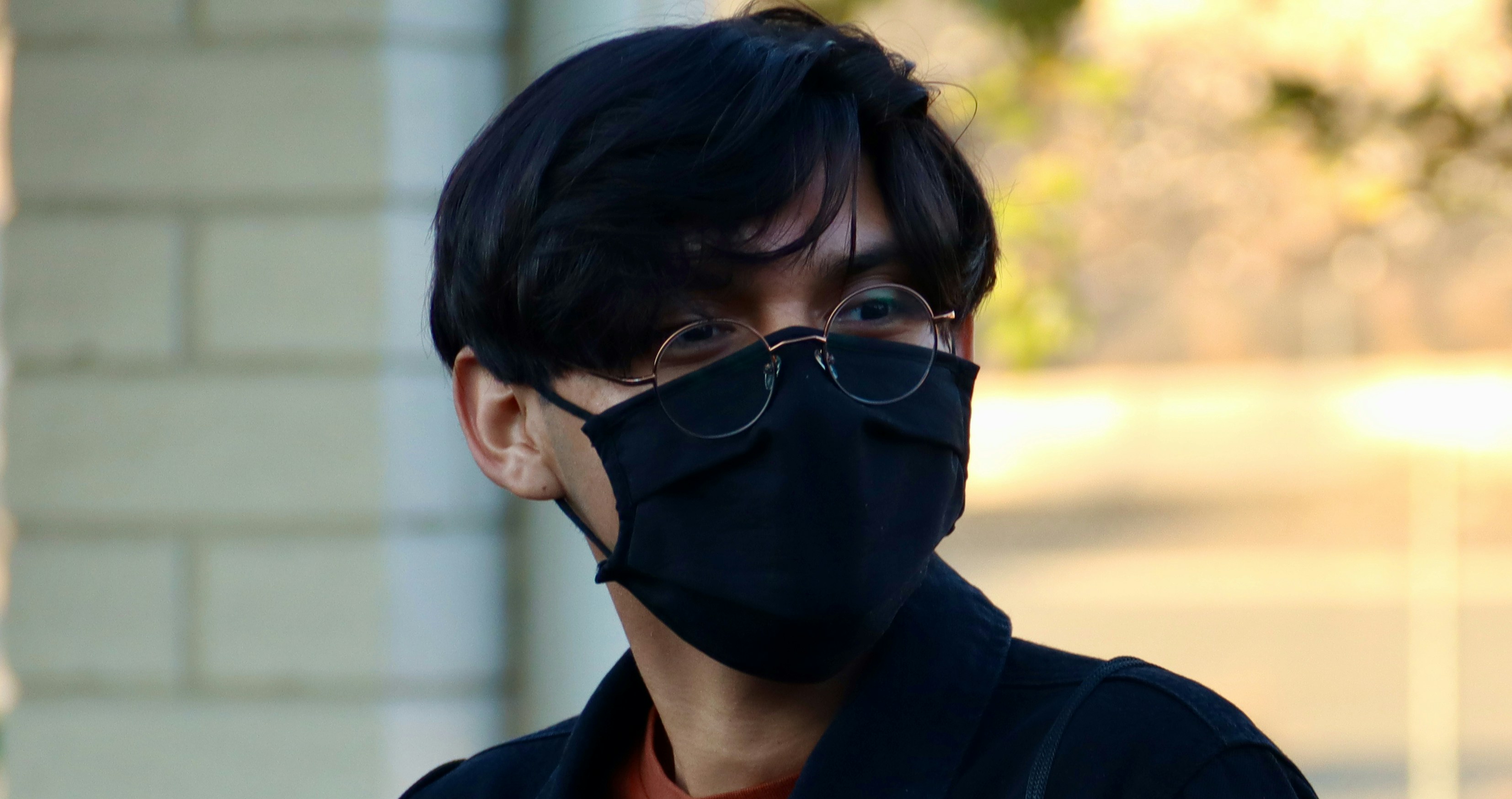 Mann mit schwarz gerahmter Brille und schwarzem Kragenhemd